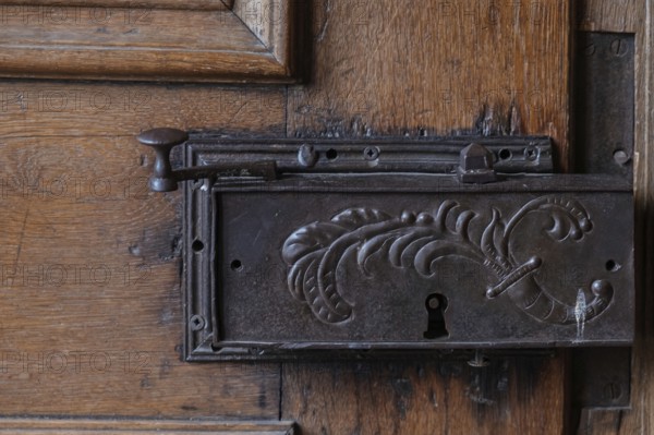 Detail of an old metal lock on a carved wooden door frame, Hesse, Germany