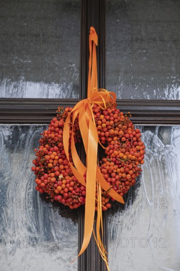 Door wreath made from orange rowanberries, Hesse, Germany