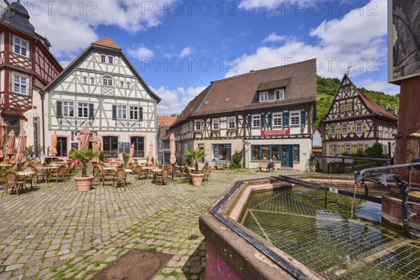 Old town, stone fountain, water, historic half-timbered houses, cobblestone square, outdoor area of a restaurant, visitors as secondary motif, blue sky, cumulus clouds, market square, intersection between Großer Markt, Marktstraße, Amtsgasse, Mühlgasse and Schunkengasse, Heppenheim, Odenwald, Bergstraße district, Hesse, Germany