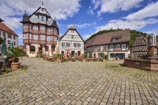 Old town, historic half-timbered houses, fountain, market fountain, cobblestone square, outdoor area of a restaurant, visitors as secondary motif, blue sky, cumulus clouds, market square, intersection between Großer Markt, Marktstraße, Amtsgasse, Mühlgasse and Schunkengasse, Heppenheim, Odenwald, Bergstraße district, Hesse, Germany