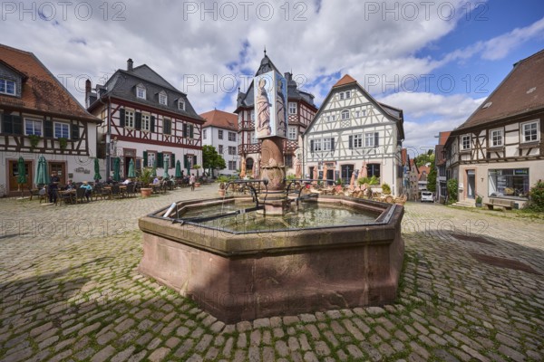 Market fountain, stone fountain, market square, cobblestone square, historic half-timbered houses, outdoor area of a restaurant, visitors as secondary motif, blue sky, cumulus clouds, market square, intersection of Großer Markt, Marktstraße and Amtsgasse, Heppenheim, Odenwald, Bergstraße district, Hesse, Germany