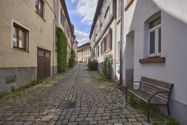 Old town, alley, cobblestone pavement, historic half-timbered houses, historic buildings, facades with windows, bench, shady, blue sky, cumulus clouds, Kleine Bach, Heppenheim, Odenwald, Bergstrasse district, Hesse, Germany