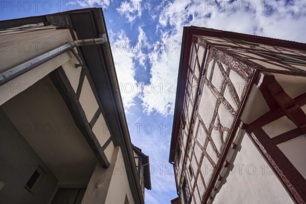 Old town, half-timbered houses, facade with downpipe, steep frog perspective, blue sky, cumulus clouds, Heppenheim, Odenwald, Bergstrasse district, Hesse, Germany