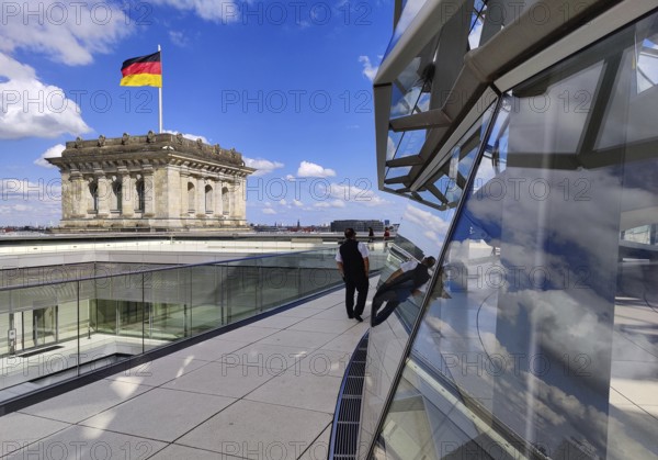 Viewing platform with a German flag in the wind on one of the corner towers and the Reichstag dome, government district, Berlin, Germany