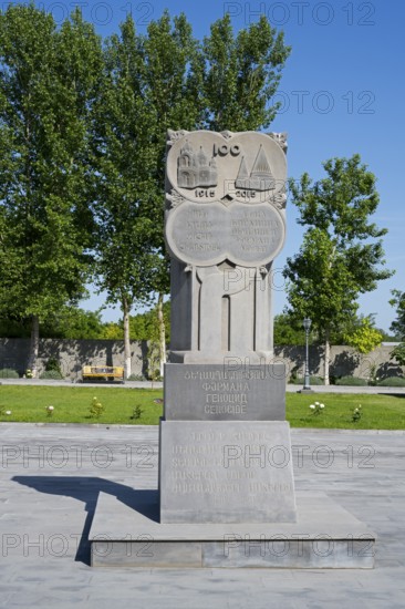 Stone monument with inscription in front of tall trees, in the garden of the Yazidi temple, Yazidi temple, Aknalich, Aknalich, Armavir district, Armenia