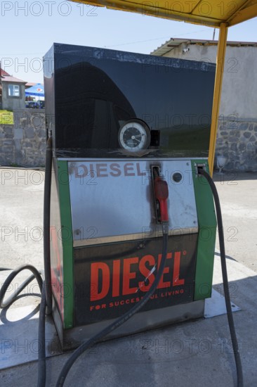 An old diesel pump at a petrol station with a large sign, diesel fuel pump, petrol station, petrol pump, Zyunik province, Armenia