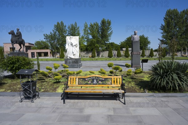 Park with colourful wooden benches, statues and surrounding trees, in the garden of the Yazidi Temple, Yazidi Temple, Aknalich, Aknalich, Armavir district, Armenia