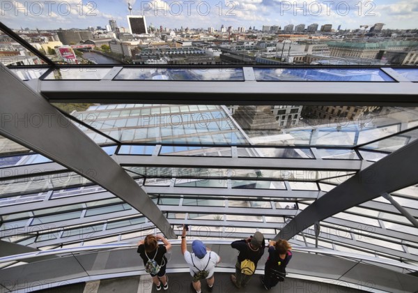 Interior view of the Reichstag dome with visitors on the ramp and view of the cityscape, Reichstag Building, Berlin, Germany