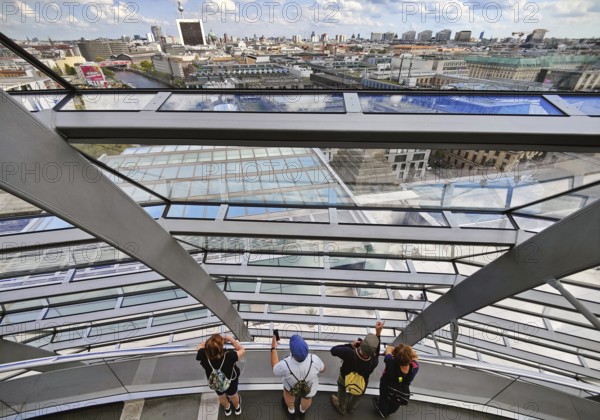 Interior view of the Reichstag dome with visitors on the ramp and view of the cityscape, Reichstag Building, Berlin, Germany