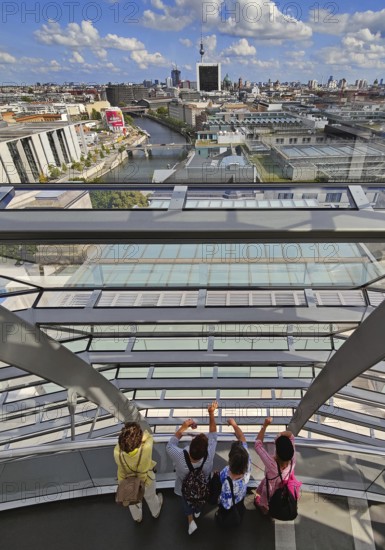 Interior view of the Reichstag dome with visitors on the ramp and view of the cityscape, Reichstag Building, Berlin, Germany