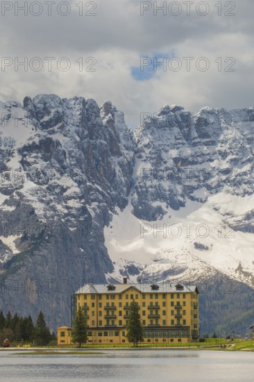 View over Lake Misurina to a building on the shore of the lake with a view towards the mountain Punta Sorapis, Misurina, Dolomites, Province of Belluno, Veneto, Italy