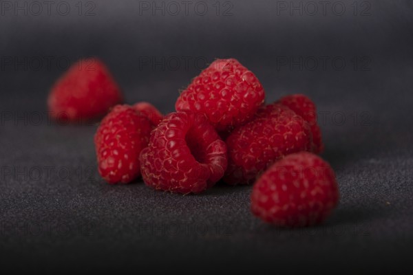 Red raspberries on dark background, selective focus
