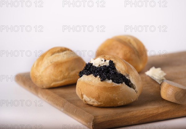 Round wheat buns with butter and black caviar, copy space