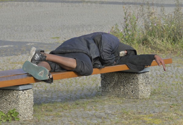 Homeless man sleeping on a bench, Ernst-Reuter-Platz, Charlottenburg, Berlin, Germany ! Personal rights are NOT clarified ! No liability for possible model release offences!