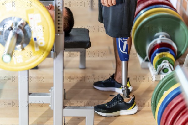 Adaptive athlete with a prosthetic leg doing weightlifting exercises on a gym bench, demonstrating strength, determination, and overcoming physical challenges through sport and fitness