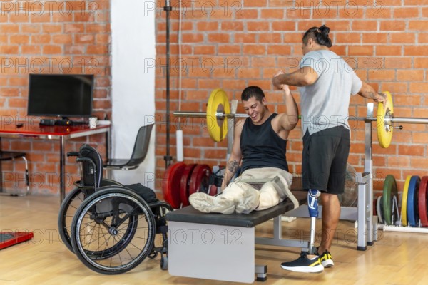 Two physically challenged men exercising together, one using a wheelchair for support on a bench press and the other standing with a prosthetic leg while spotting him