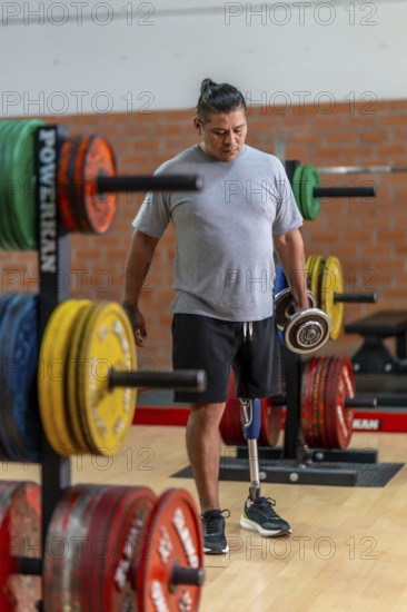 Man with prosthetic leg training at the gym, carrying heavy weights, demonstrating strength, determination, and overcoming physical challenges through adaptive fitness