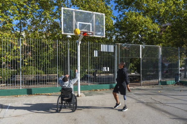 Men with prosthetic leg and wheelchair playing basketball outdoors, demonstrating inclusion, perseverance, and active lifestyle while enjoying adaptive sports