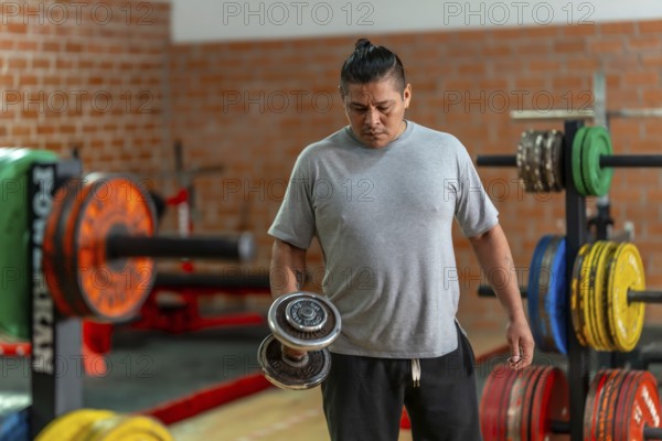 Mature man concentrating on a bicep curl with a dumbbell in a gym, focused on strength training, muscle development and determined fitness routine for health and well being