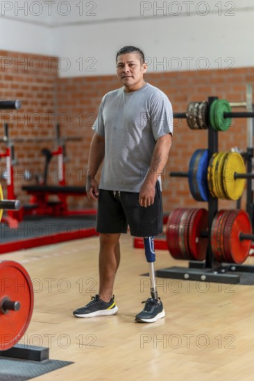Male amputee athlete standing confidently in a gym, showcasing his prosthetic leg and symbolizing resilience, fitness, and overcoming challenges in a modern and active lifestyle