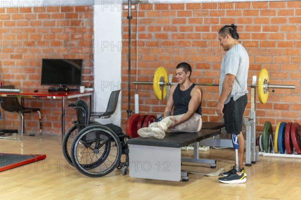 Two adaptive athletesone with a prosthetic leg and one using a wheelchairsupport each other during gym training, showcasing inclusion, teamwork, and active recovery