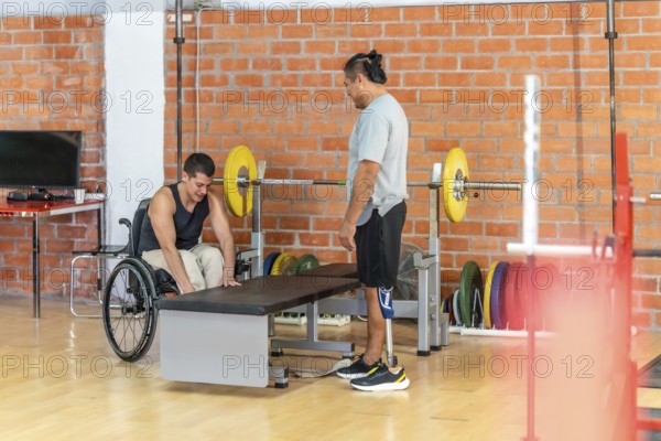 Adapted athletes focusing on their fitness routine at a gym, with one man using a wheelchair and another man standing with a prosthetic leg, promoting diversity and resilience