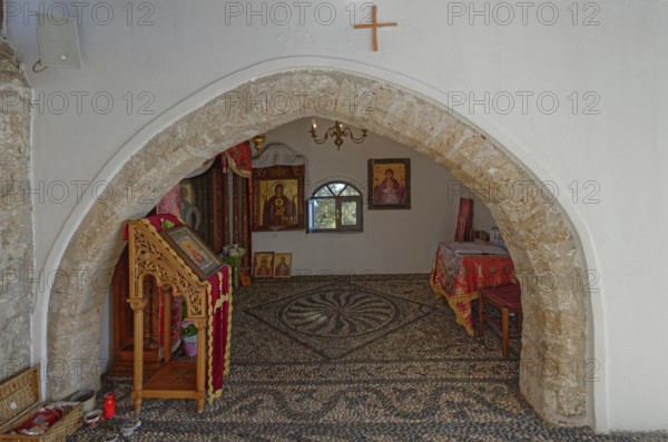 Interior of a church of the Virgin Mary Tsambika (Kyra Psili), with stone arch and icons, spacious room with calm lighting and traditional decorative elements, Church of the Virgin Mary Tsambika (Kyra Psili), Archangelos, Rhodes Island, Greece