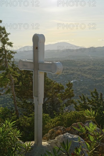 A wooden cross on a hill with a view of mountains and wooded landscape, Church of the Virgin Mary Tsambika (Kyra Psili), Archangelos, Rhodes Island, Greece