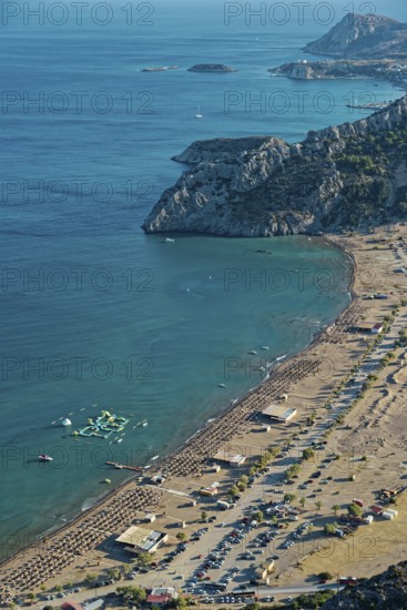 View of the sunny coastal landscape of Tsambika with sandy beach, blue sea and cliffs, Church of the Virgin Mary Tsambika (Kyra Psili), Archangelos, Rhodes Island, Greece