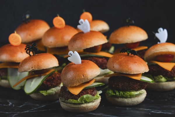 Small burgers with lettuce, cheese, tomatoes and cucumber, Halloween decoration