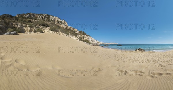 Extensive Tsambika sandy beach with rocks and calm turquoise sea under a clear blue sky, Tsambika beach, Archaggelos, Rhodes island, Greece