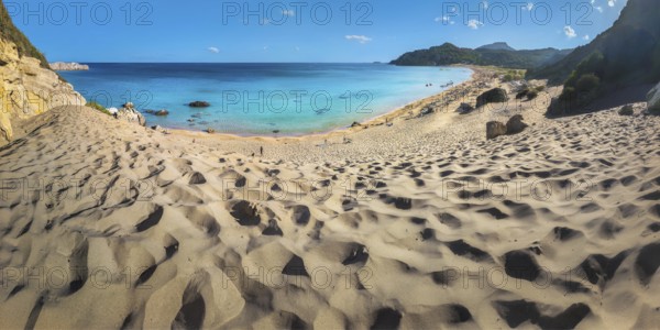 Picturesque Tsambika beach with sandy dunes, clear blue sea and rocks under a blue sky, Tsambika beach, Archaggelos, Rhodes island, Greece