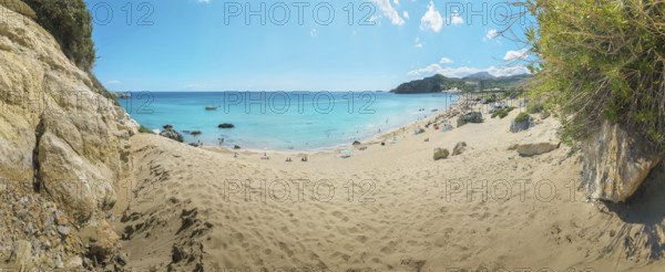 A quiet place on Tsambika sandy beach of Tsambika with clear blue sea and rocks under a sunny sky, ideal for relaxation, Tsambika beach, Archaggelos, Rhodes island, Greece