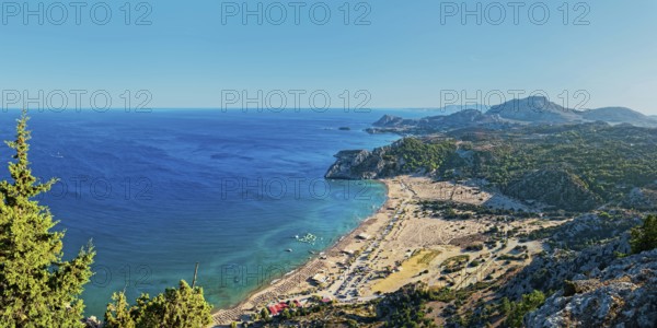 Coastal landscape of Tsambika with blue sea, wide beach and green hills under a clear sky, Tsambika beach, Archaggelos, Rhodes island, Greece
