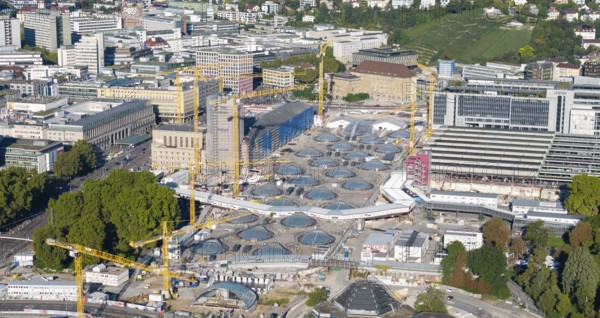 View of an urban construction site with cranes and modern glass structures, surrounded by green spaces, large construction site, Stuttgart railway station, Stuttgart 21, Baden-Württemberg, Germany