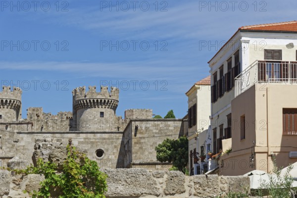 Castle with medieval stone towers next to a Mediterranean building under a blue sky, Grand Master's Palace, Roloi Clock Tower, Medieval Town of Rhodes, Rhodes Island, Greece