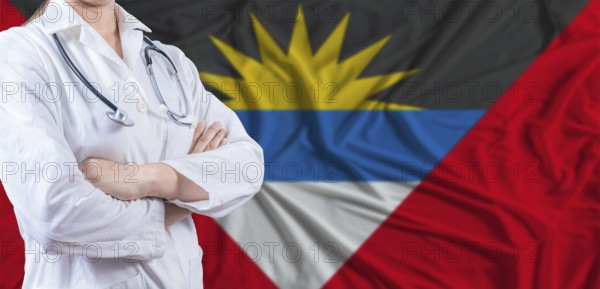 Doctor with crossed arms on Antigua and Barbuda flag. Antigua and Barbuda health and care concept. Female doctor on Antigua and Barbuda flag