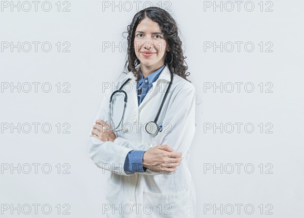Portrait of smiling latin female doctor with crossed arms on isolated background. Success young female doctor with crossed arms looking at camera