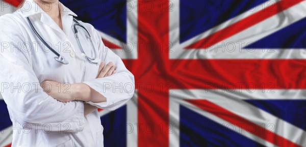 Doctor with crossed arms on United Kingdom flag. United Kingdom health and care concept. Female doctor on United Kingdom flag