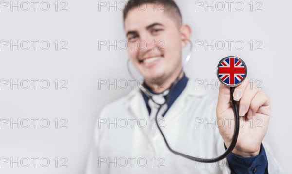 Doctor showing stethoscope with United Kingdom flag. United Kingdom national healthcare concept
