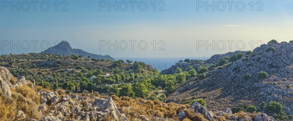 Hilly landscape near Stegna with green vegetation, sea view and blue sky, Stegna, Archangelos, Rhodes Island, Greece