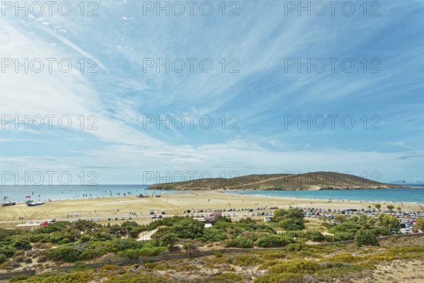 Spacious sandy beach of Prasonisi overlooking the sea and a small island under a blue sky with clouds, Prasonisi, Rhodes Island, Greece