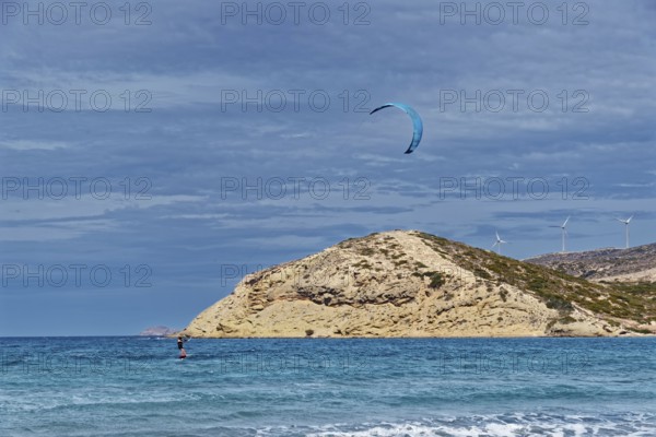 Prasonisi beach with a view of the sea and rocky island with visible kite and wind turbines. Windy coastal landscape, Prasonisi, Rhodes Island, Greece