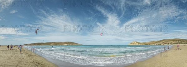 Spacious beach of Prasonisi with light sand, blue sea and two kite surfers under a cloudy sky, Prasonisi, Rhodes Island, Greece