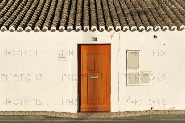 House with orange door, old building in the historic centre of Tavira, Algarve, Portugal