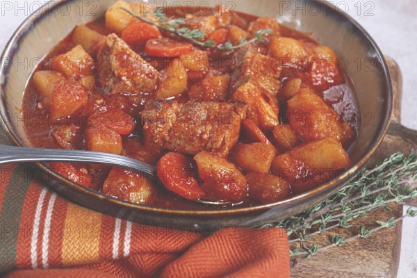 Meat goulash with potatoes and carrots, sweet peppers, in a saucepan, top view, traditional Hungarian soup, homemade, no people