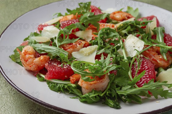 Fresh shrimp salad with arugula, grapefruit, and parmesan served in a bowl