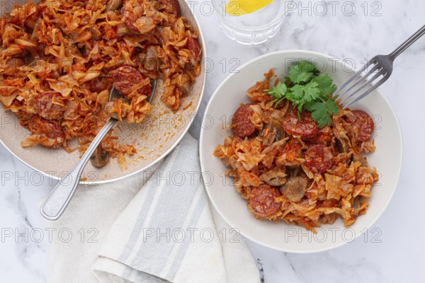 Bigos, Polish dish bigos, on the table, pan with stewed meat, with cabbage, chorizo sausages, mushrooms, homemade, without people