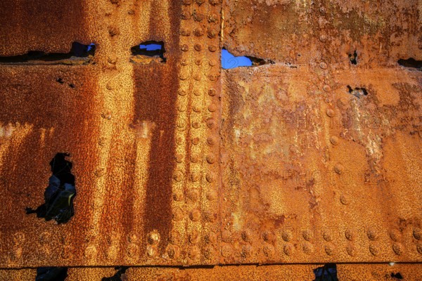 The rough texture of heavily corroded iron plates on the hull of. derelict ship. British Columbia, Canada
