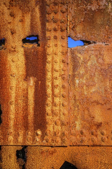 The rough texture of heavily corroded iron plates on the hull of. derelict ship. British Columbia, Canada